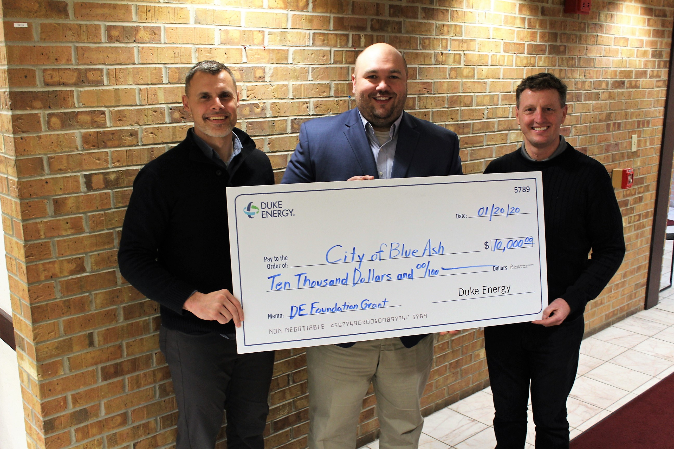 Blue Ash Parks and Recreation Director Brian Kruse, Duke Energy Sr. Government Affairs Specialist J. Chad Shaffer, and Blue Ash City Manager David Waltz holding giant check